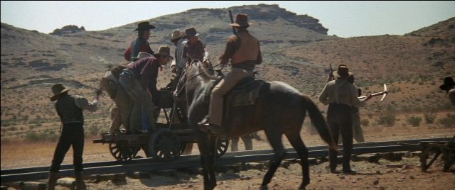 Wide shot frame from Blazing Saddles — sitting, standing, dialogue