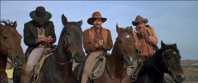 Wide shot frame from Blazing Saddles — sitting, dialogue, hat