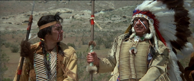 Wide shot frame from Blazing Saddles — standing, dialogue, hand