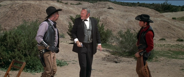 Wide shot frame from Blazing Saddles — standing, dialogue, hand