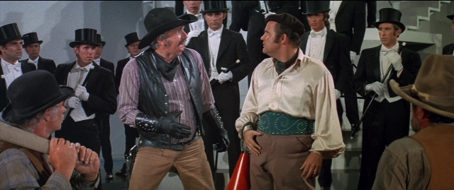 Wide shot frame from Blazing Saddles — standing, dialogue, hat