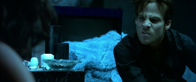 Medium shot frame from Blade — sitting, bed, shirt