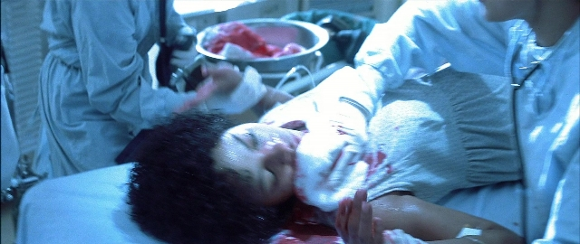 Wide shot frame from Blade — room, bed, face