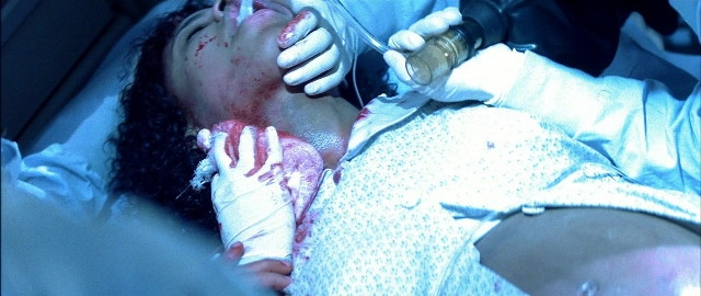 Wide shot frame from Blade — bed, hand, face