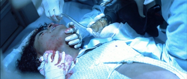 Wide shot frame from Blade — bed, hand, face