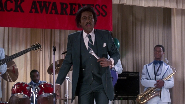 Wide shot frame from Coming to America — standing, dialogue, suit