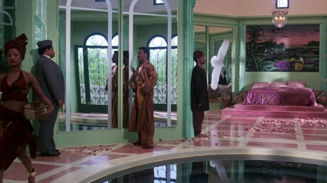 Wide shot frame from Coming to America — standing, room, bed