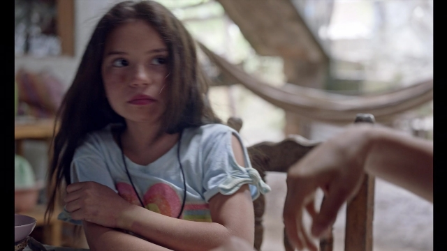 Medium shot frame from Noche de Fuego — sitting, room, table