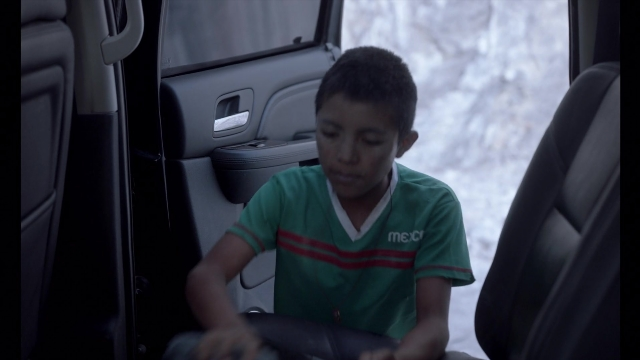 Wide shot frame from Noche de Fuego — sitting, street, car