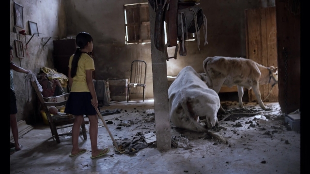 Wide shot frame from Noche de Fuego — standing, room, door
