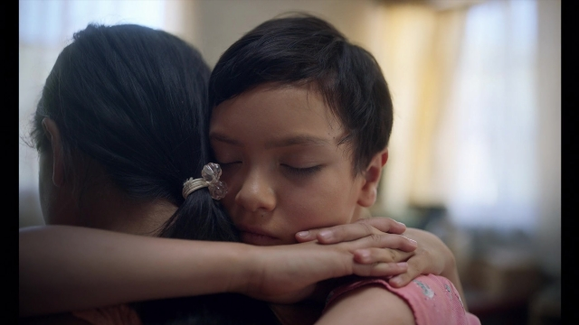 Wide shot frame from Noche de Fuego — room, dress, face