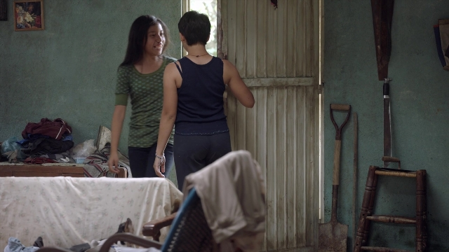 Wide shot frame from Noche de Fuego — standing, room, dialogue