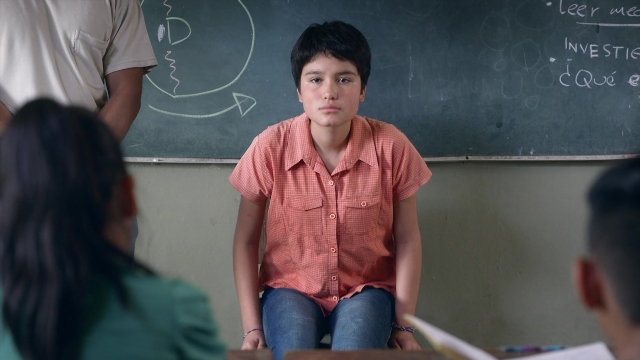 Wide shot frame from Noche de Fuego — sitting, shirt, face
