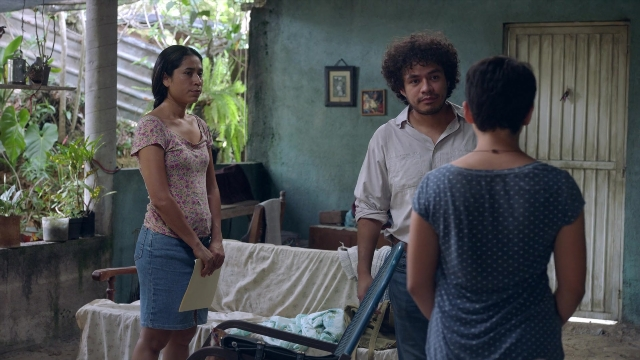 Wide shot frame from Noche de Fuego — standing, room, dialogue