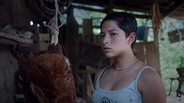 Wide shot frame from Noche de Fuego — standing, room, face