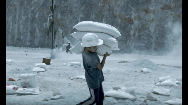 Wide shot frame from Noche de Fuego — walking, street, hat