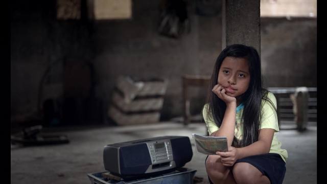 Wide shot frame from Noche de Fuego — sitting, room, shirt
