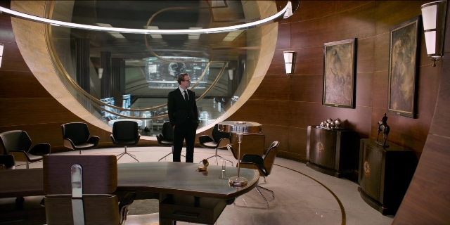 Wide shot frame from Men in Black International — standing, room, suit
