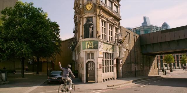 Frame from Men in Black International — street, car, bicycle