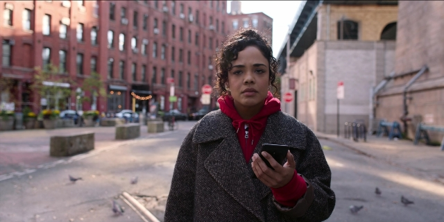 Wide shot frame from Men in Black International — standing, phone, street