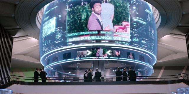 Wide shot frame from Men in Black International — suit, tie, beard