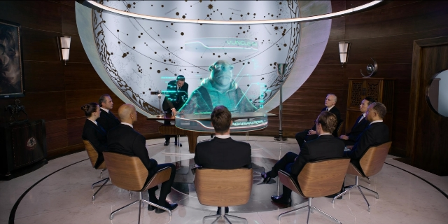 Wide shot frame from Men in Black International — sitting, standing, room