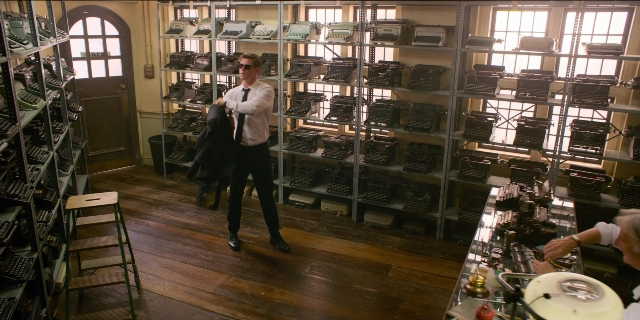 Wide shot frame from Men in Black International — standing, room, hand