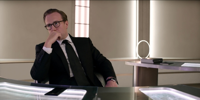 Frame from Men in Black International — sitting, table, phone