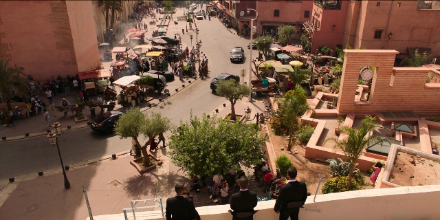 Wide shot frame from Men in Black International — walking, street, clock