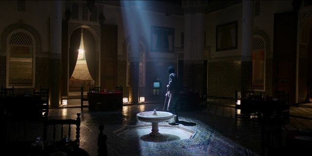 Wide shot frame from Men in Black International — standing, room, fountain