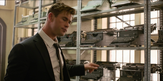 Wide shot frame from Men in Black International — standing, room, door