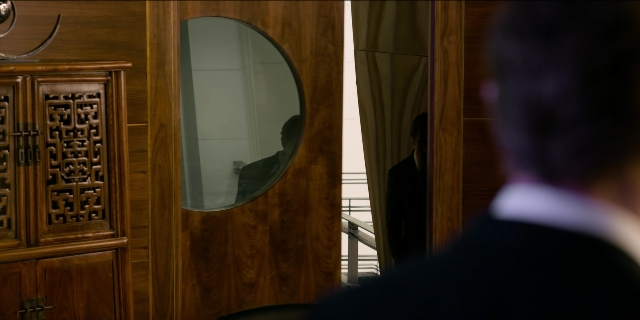 Wide shot frame from Men in Black International — room, mirror, suit