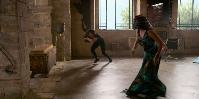 Wide shot frame from Men in Black International — room, dress, chair