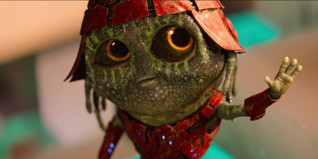 Wide shot frame from Men in Black International — hand, toy, human face
