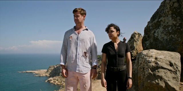 Wide shot frame from Men in Black International — standing, shirt, water