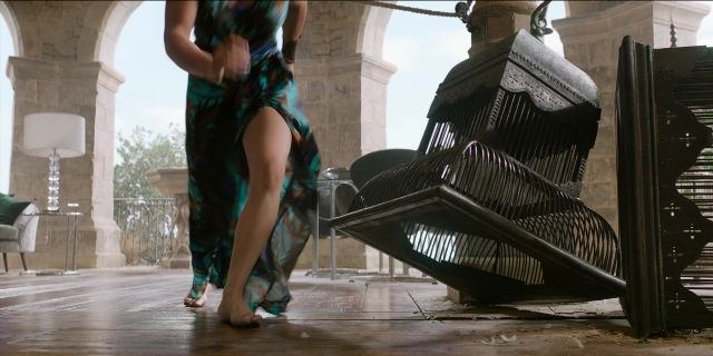 Wide shot frame from Men in Black International — walking, table, dress