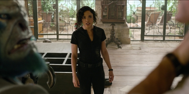Wide shot frame from Men in Black International — standing, room, shirt