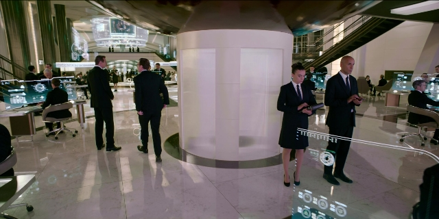 Wide shot frame from Men in Black International — sitting, standing, dialogue