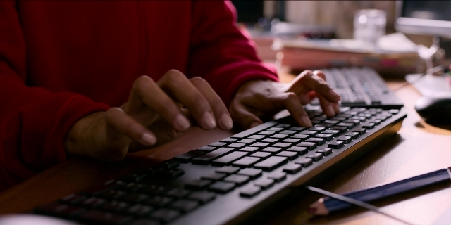 Frame from Men in Black International — sitting, desk, office