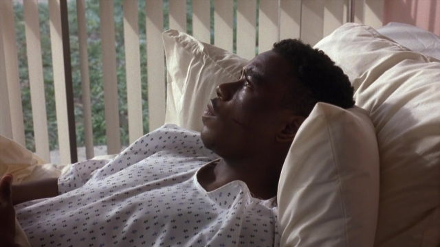 Wide shot frame from Menace II Society — bed, pillow, person