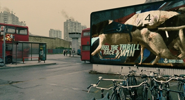 Wide shot frame from Children of Men — street, hat, dog
