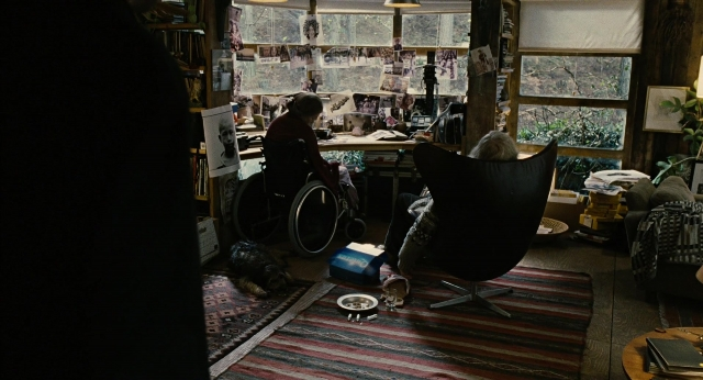 Wide shot frame from Children of Men — sitting, desk, room