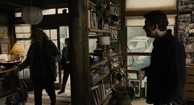 Wide shot frame from Children of Men — standing, room, dog