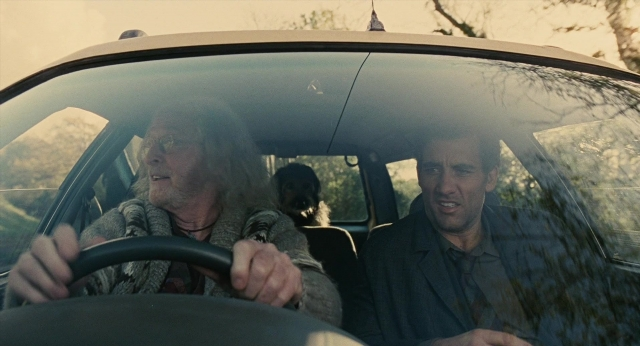 Wide shot frame from Children of Men — sitting, street, dog