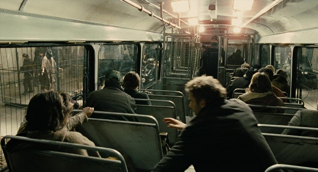Wide shot frame from Children of Men — sitting, standing, car
