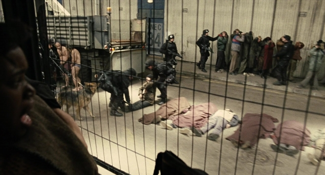 Wide shot frame from Children of Men — standing, dog, coat