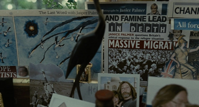 Wide shot frame from Children of Men — room, table, suit