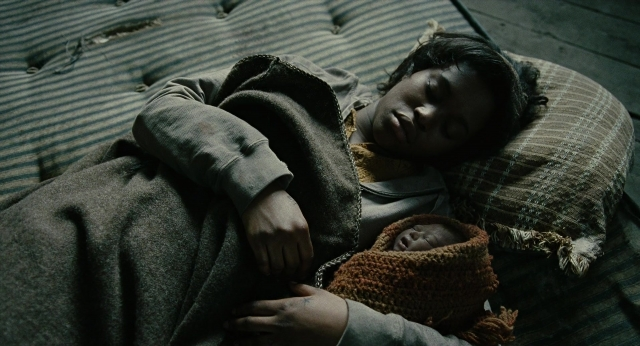 Frame from Children of Men — bed, person, human face