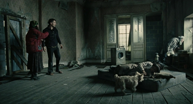 Wide shot frame from Children of Men — standing, room, table