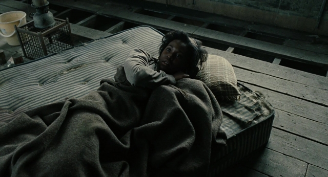 Wide shot frame from Children of Men — room, bed, face